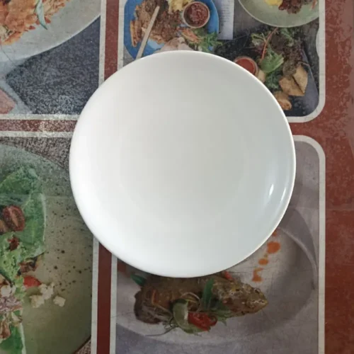 Piring putih di atas taplak