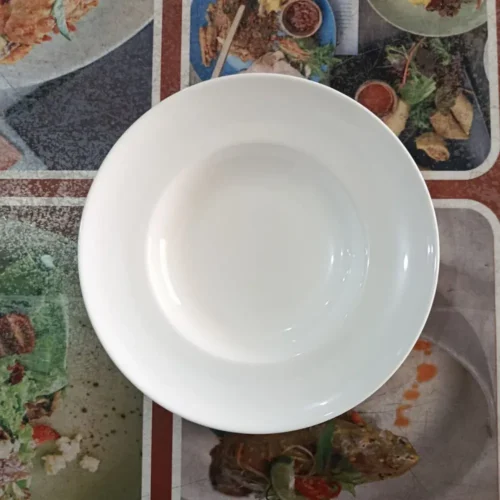 piring putih kosong di atas meja