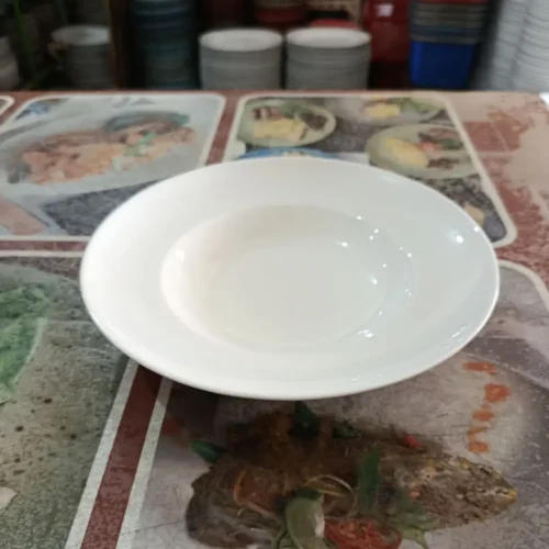 Piring putih cekung di atas taplak