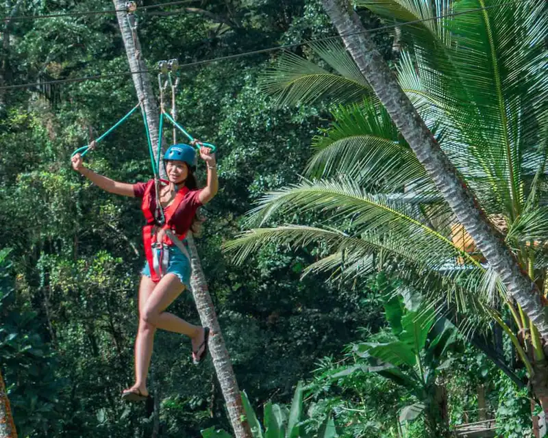 Wanita bermain flying fox di hutan