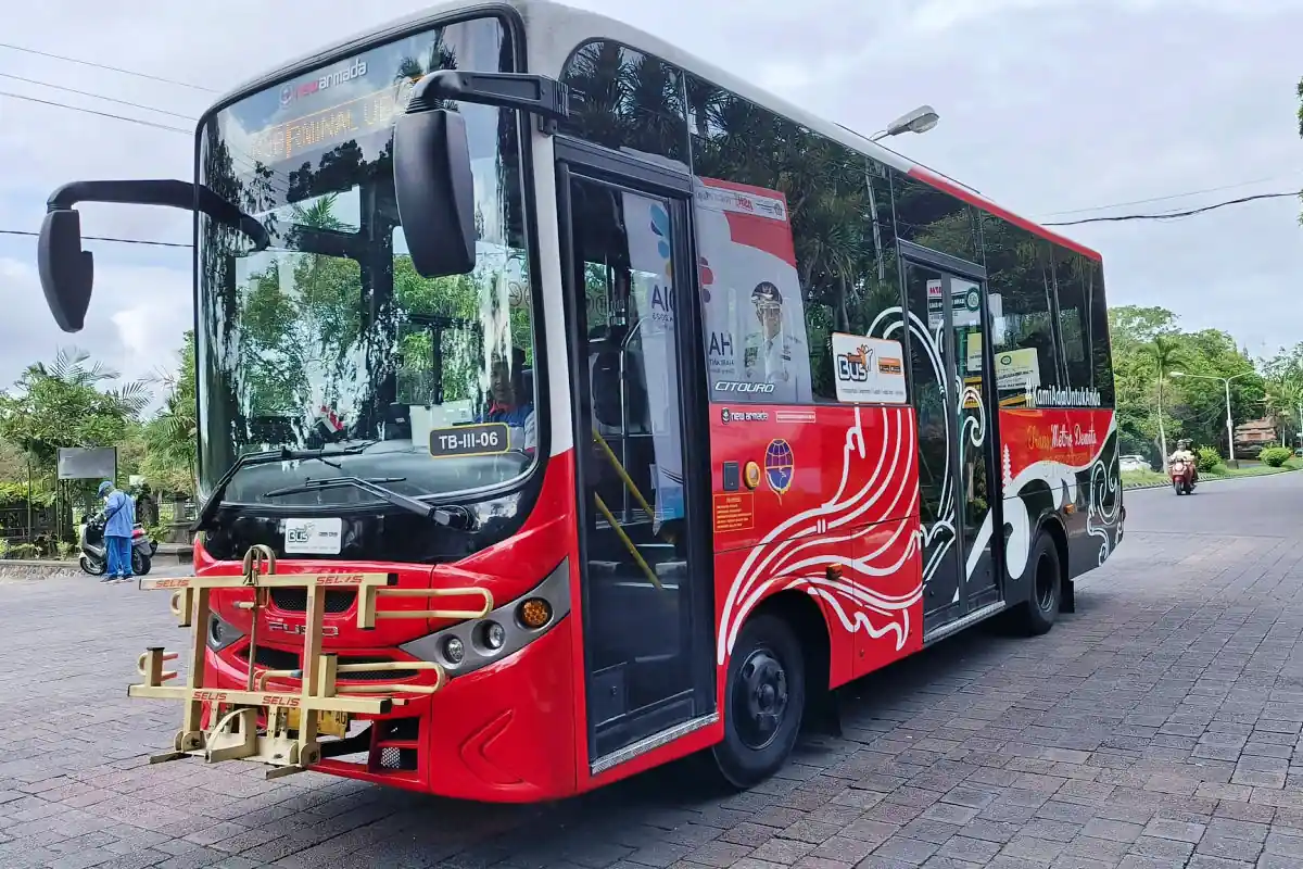 Bus merah berhenti di pinggir jalan.