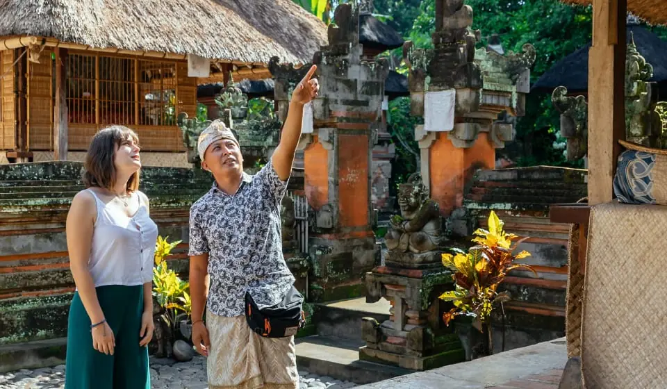 Turis dan pemandu di pura
